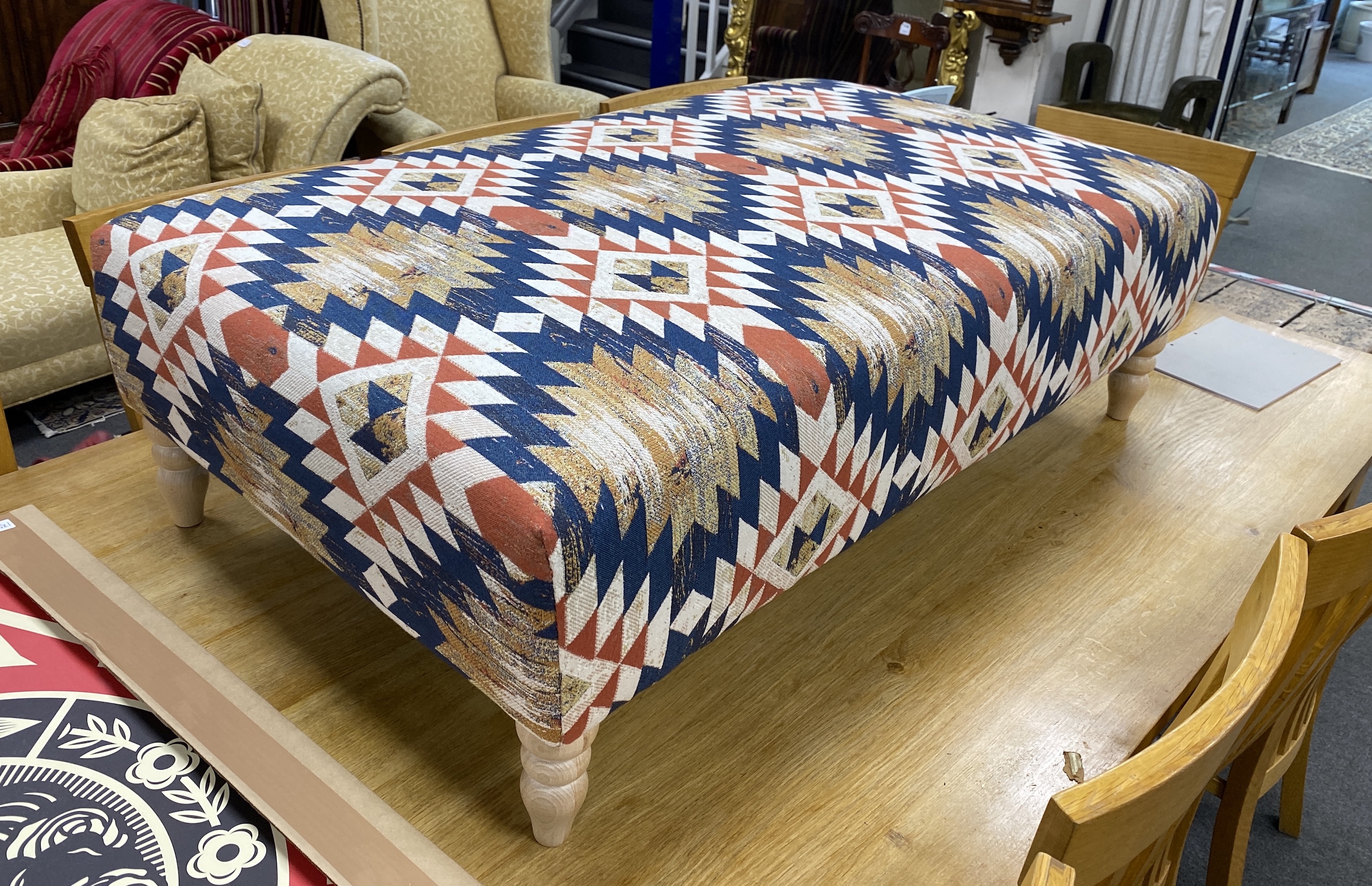 A large contemporary rectangular footstool upholstered in Kilim style polychrome fabric on turned beech feet, length 124cm, depth 75cm, height 38cm